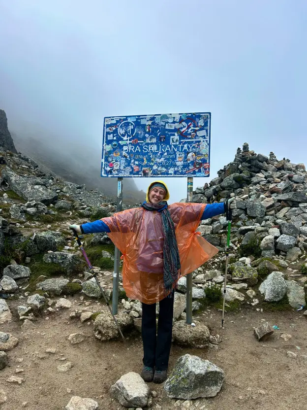 Angelina with her arms wide open on a misty mountain path
